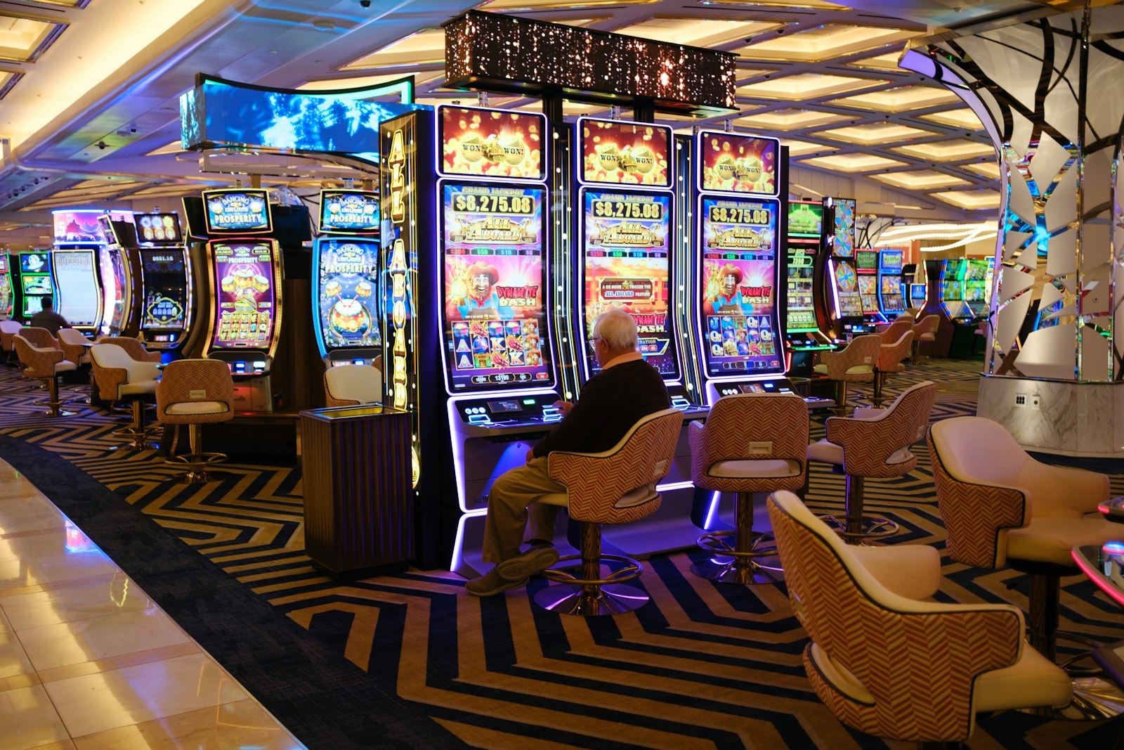 Ruang kasino dengan deretan mesin slot yang menyala